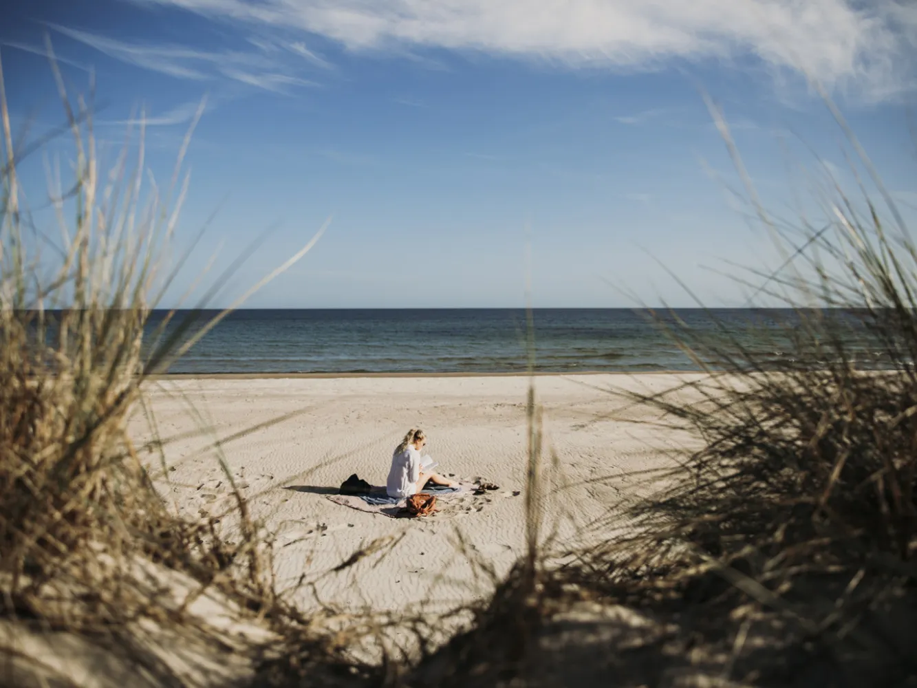 Kvinna som sitter på en sandstrand