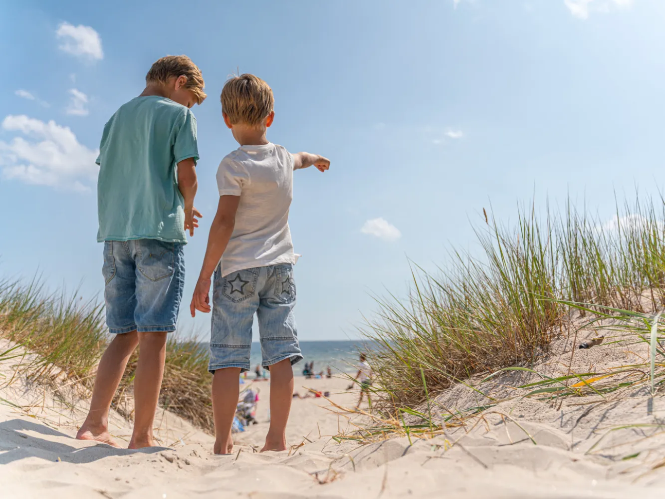 Två små killar pekar ut mot vattnet vid Bödabukten på Öland