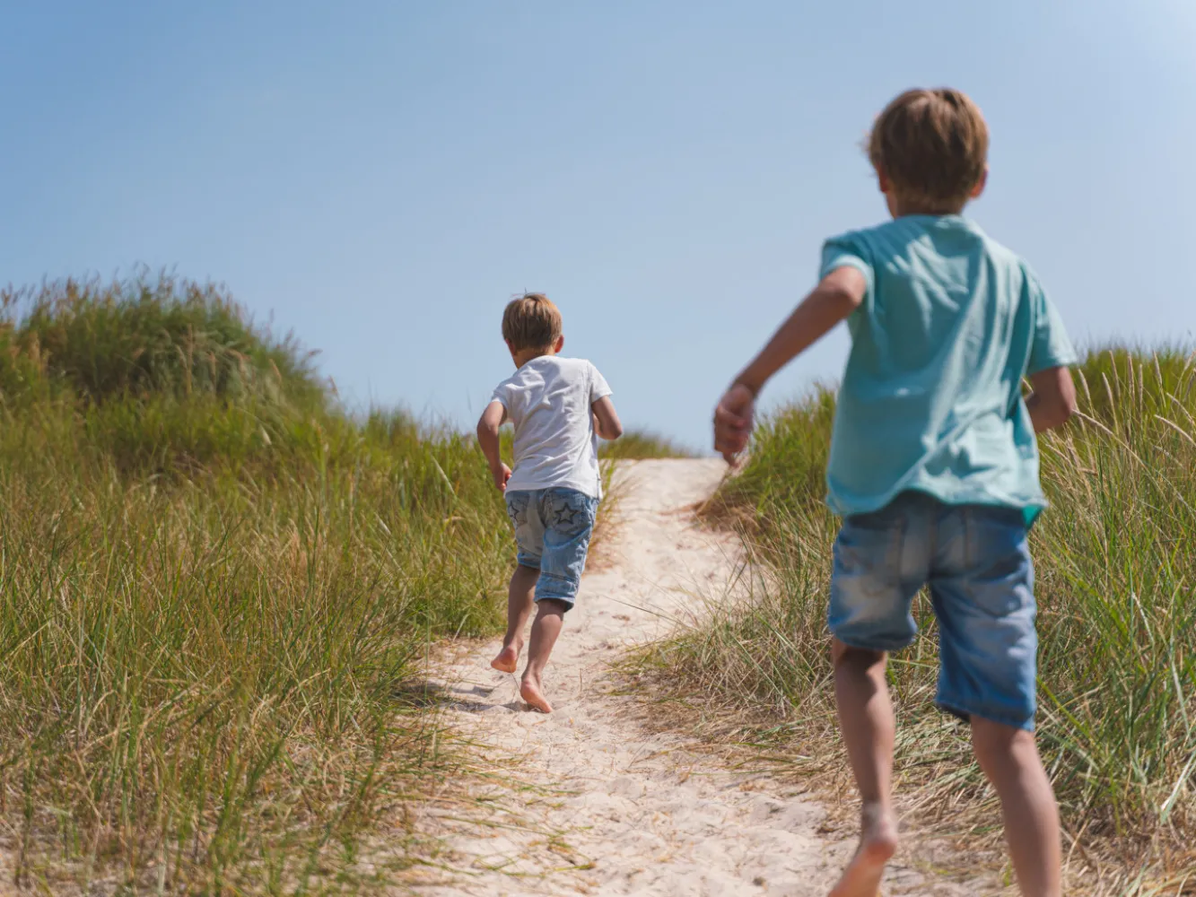 Två barn som springer på en strand