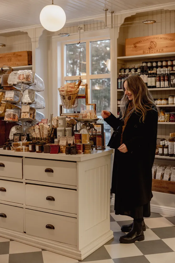 Kvinna står i en butik och kollar på produkter
