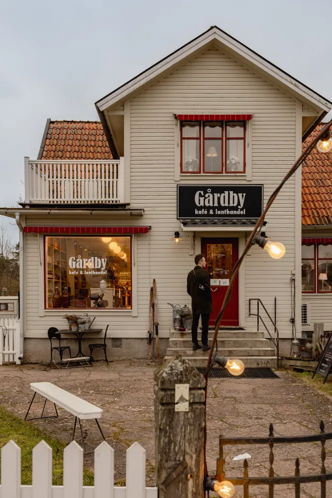 En man står framför entrén för Gårdby Lanthandel