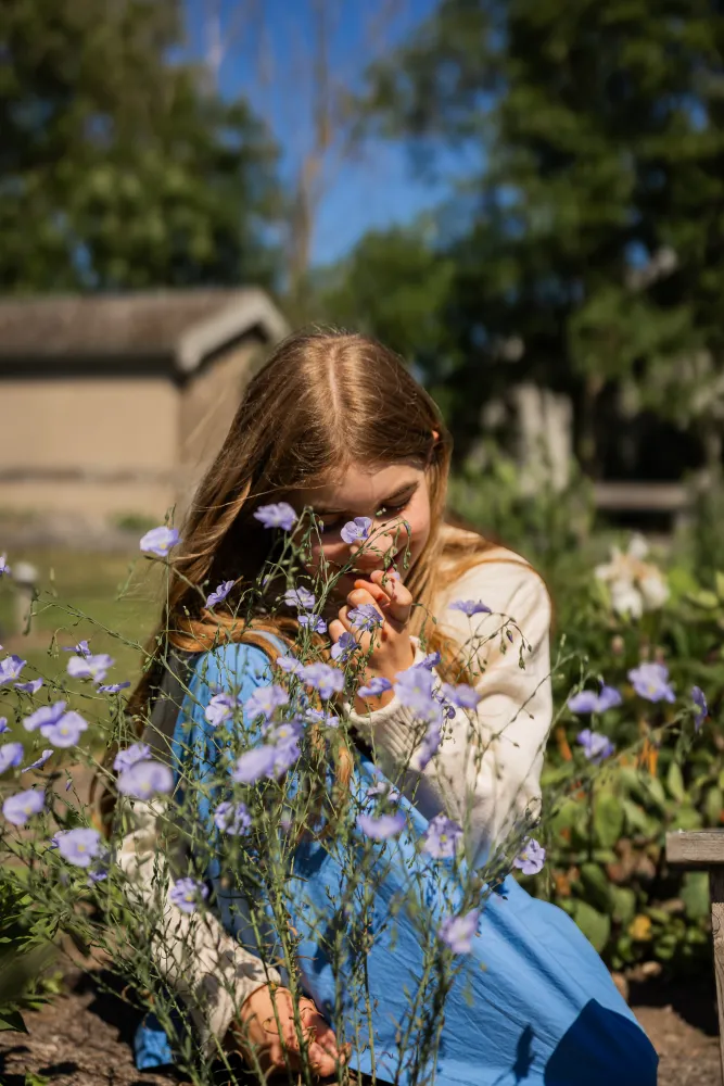 Flicka som diktar på lila blommor