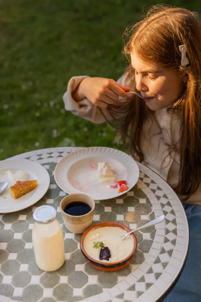 En flicka äter desserter som står framdukade på ett bord