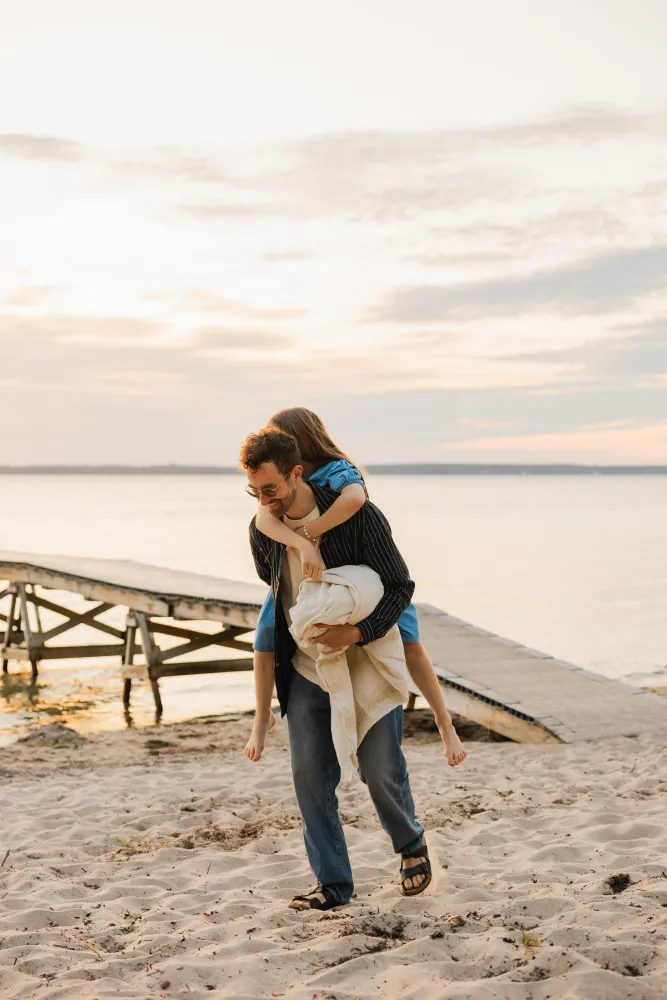 Familj som leker på stranden i solnedgången