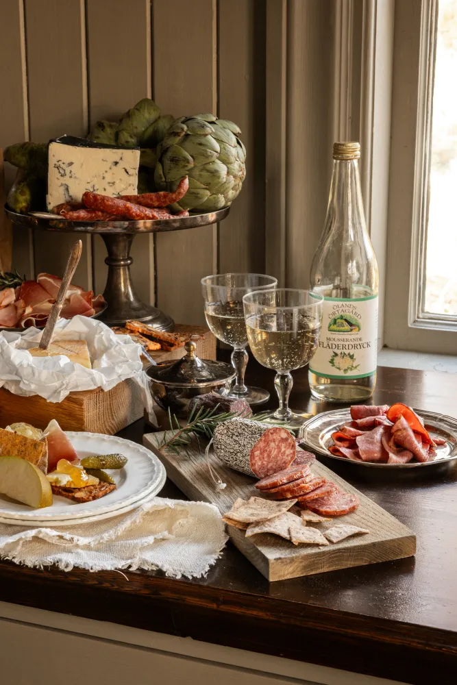 bord uppdukat med dricka, chark, bröd och smör