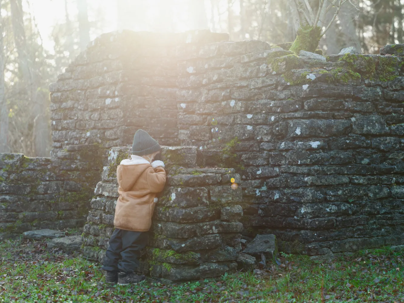 En liten flicka leker kurragömma vid en gammal ruin vid Penåsa på södra Öland.