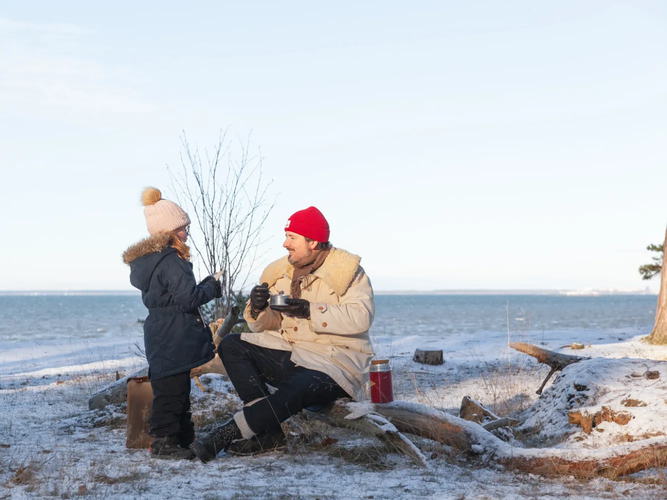 Vinterutflykt till Sandbergen på Öland. En pappa och dotter dricker varm choklad och blickar ut mot havet..