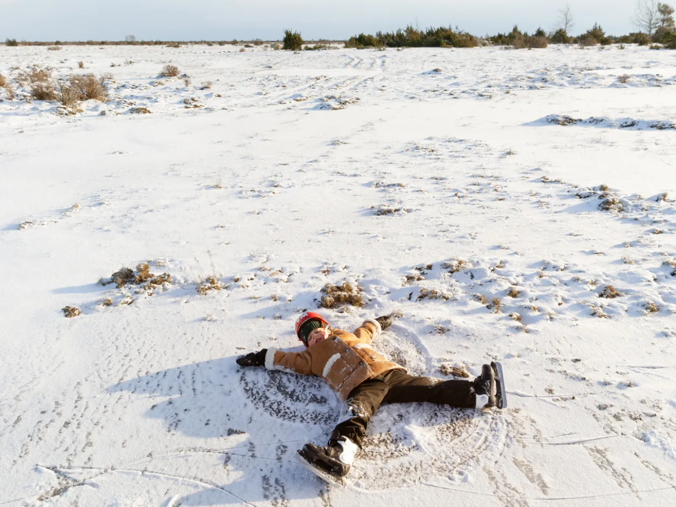 Vinterutflykt med Helena Elm. Helenas dotter gör en snöängel i pudersnön som ligge rpå mossen.