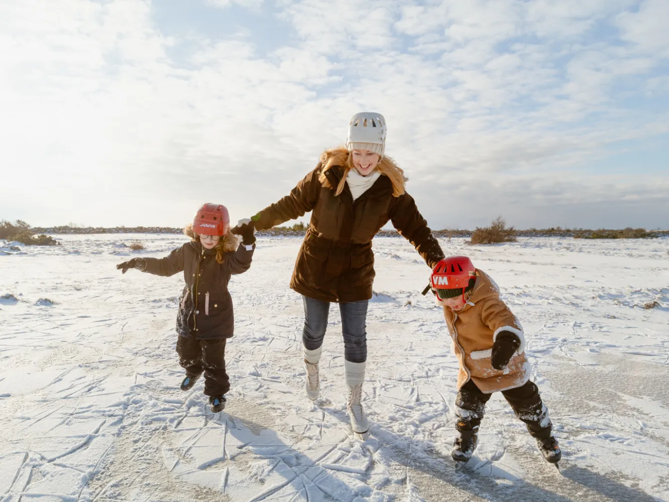 Vinterutflykt med Helena Elm. På en frusen moss på alvaret åker Helena skridskor med sina döttrar i varsin hand.