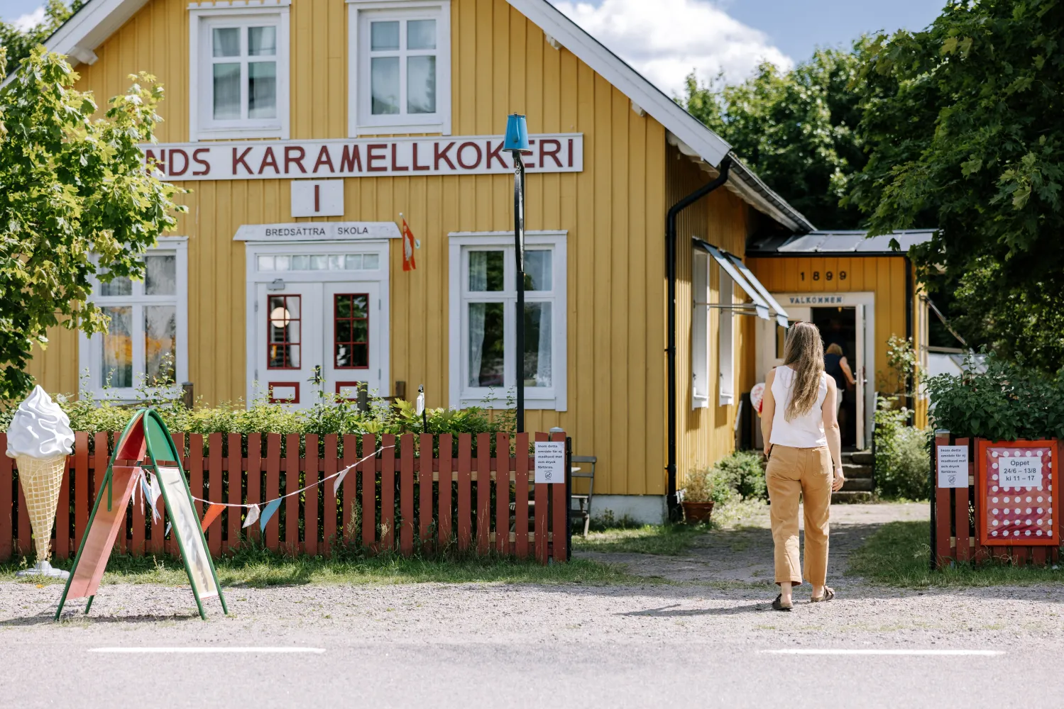 kvinna går mot en gulbyggnad