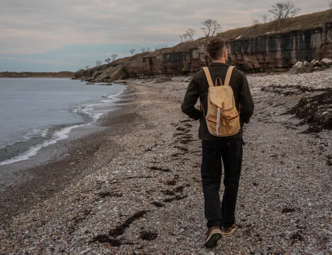 En man går på en stenstrand på norra Öland