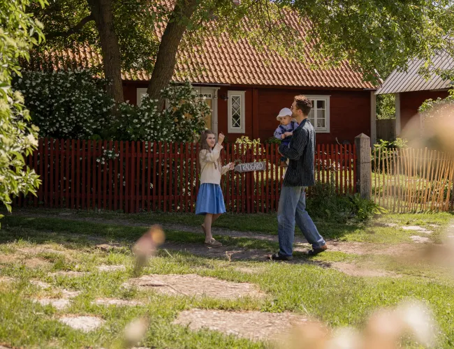 Familj promenerar genom en kringsbyggd ölandsgård