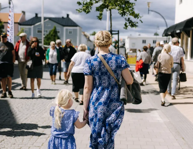 En mamma och dotter håller varann i handen medans de strosar runt i Borgholm