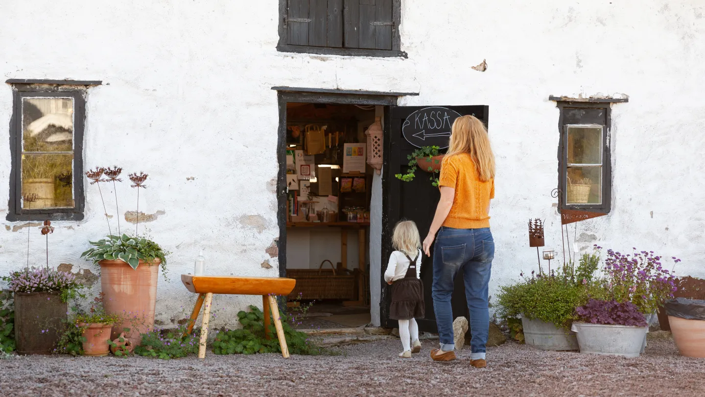 Barn och vuxen går in i gårdsbutik.