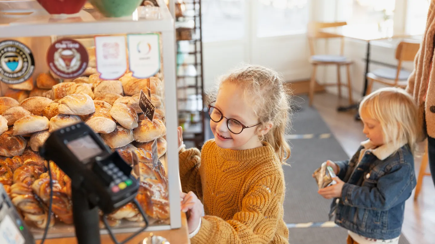 Barn som står och kollar på fika