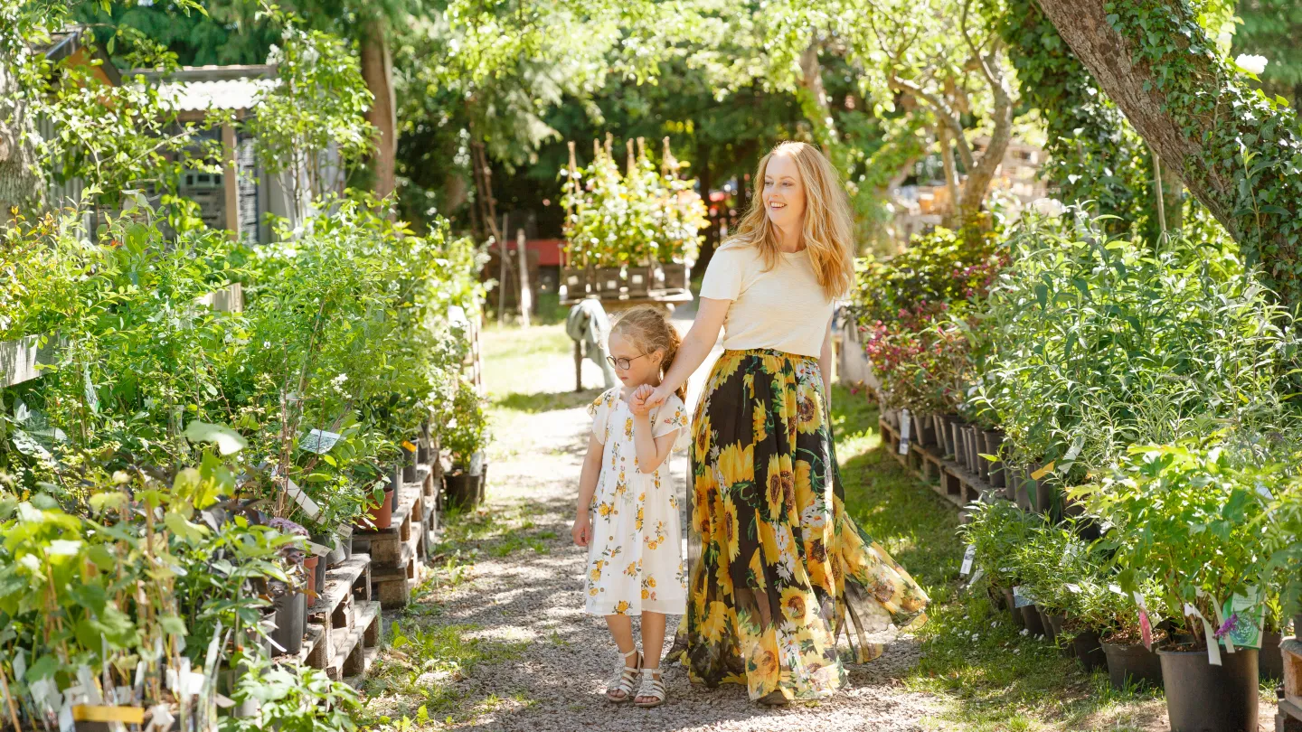 Kvinna och barn som går i Borgholms Handelsträdgården 