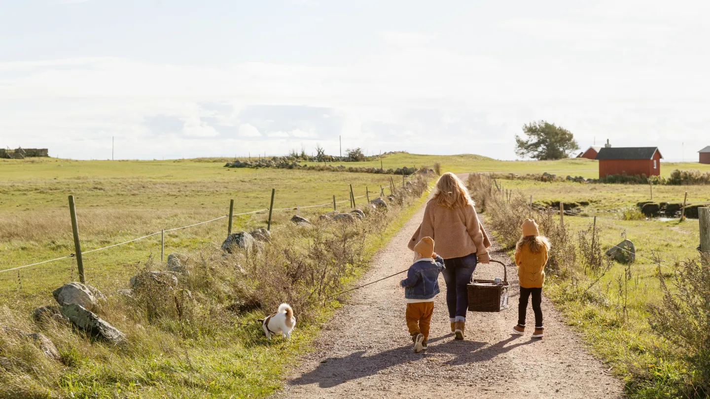 Familj som promenerar på en grusväg.