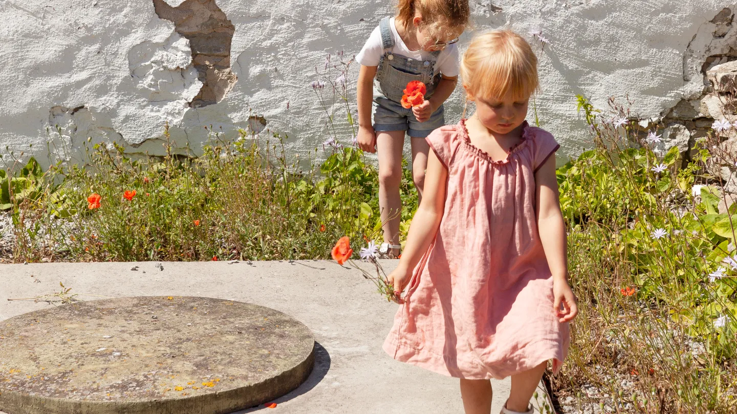 Barn plockar blommor utanför Ninnis Kroppkaksbod