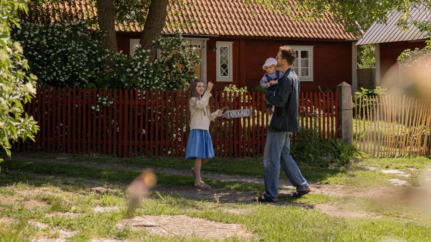 Familj promenerar genom en kringsbyggd ölandsgård