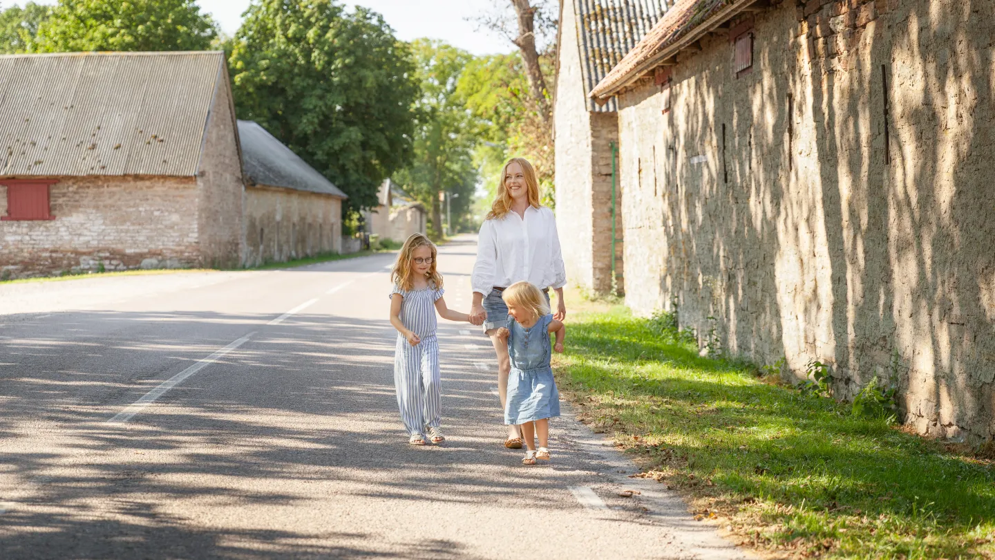 Familj går längs vägen i en radby