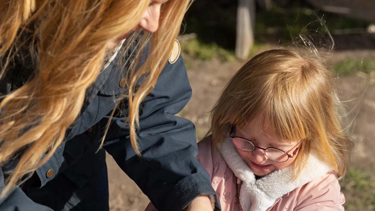 Barn och vuxen bakar bröd tillsammans utomhus.