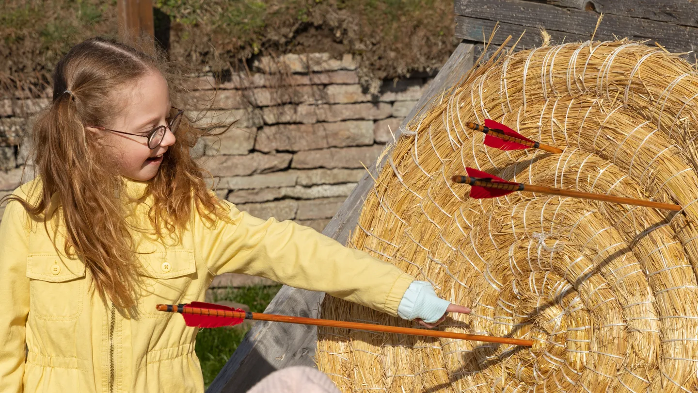 Barn kollar på en pilbåge måltavla 