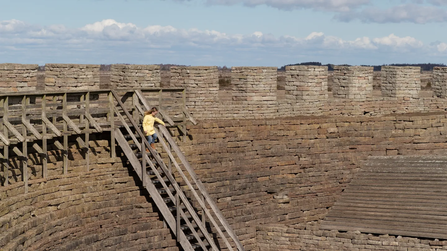 Besökare går i en trappa i Eketorps borg.
