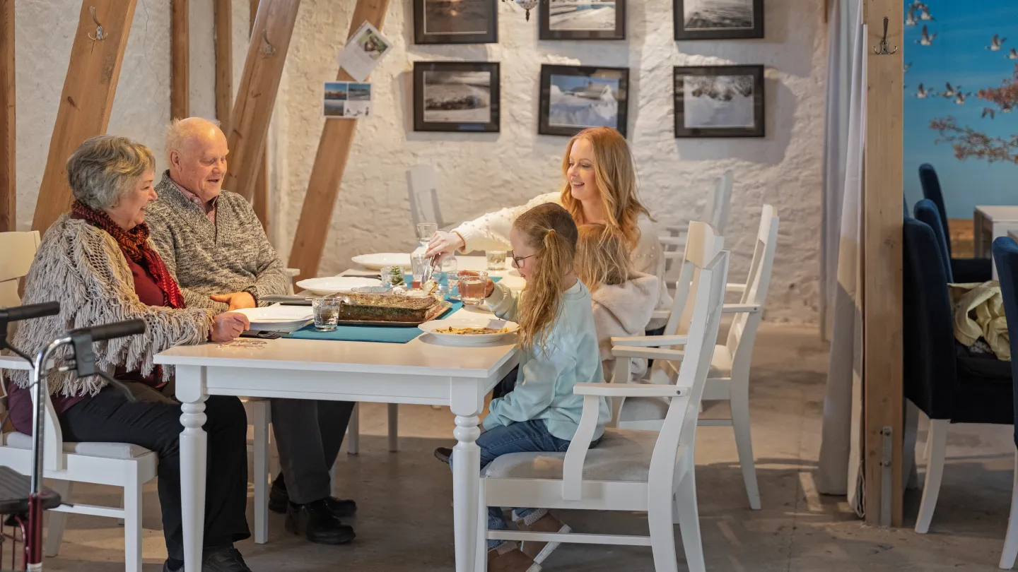 Personer sitter tillsammans och äter.