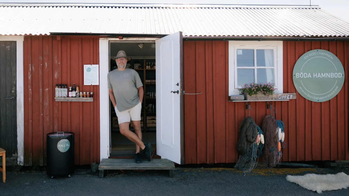 En man med hatt står i dörröppningen till Böda hamnbod.