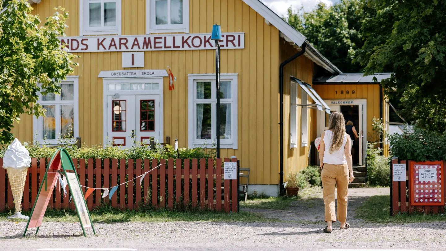 kvinna går mot en gulbyggnad